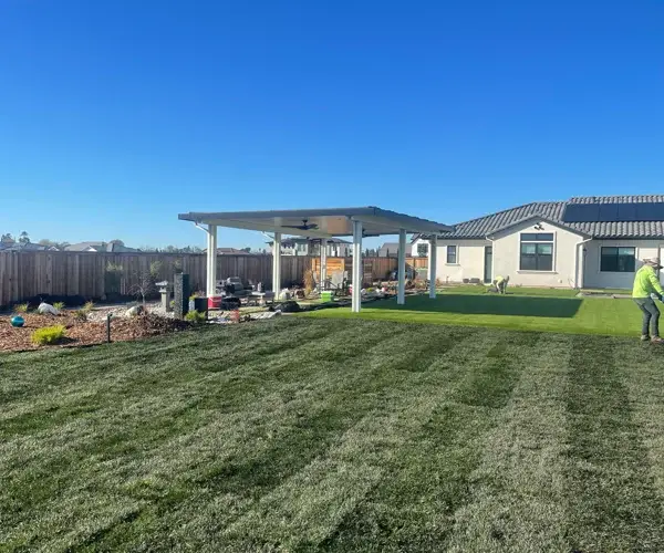 Residential landscaping in Granite Bay, CA, featuring a well-maintained lawn, modern patio structure, and outdoor living space, showcasing Rogers Landscape's design and craftsmanship.