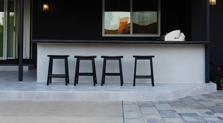 Custom outdoor bar counter with four black stools, designed for social gatherings, enhancing outdoor living spaces in Loomis, CA.