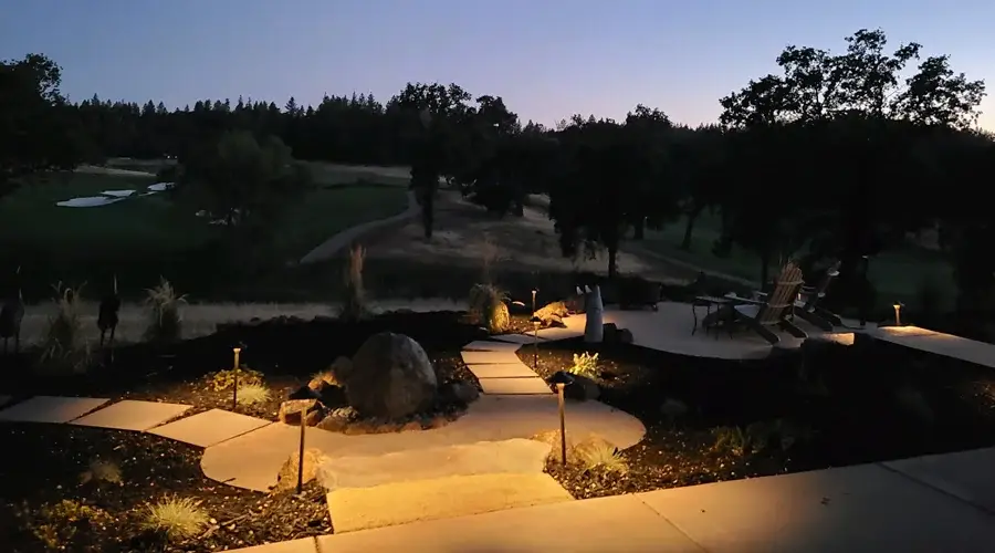 Pathway illuminated by low-voltage landscape lighting, featuring stone walkways, accent lights, and surrounding greenery, creating a warm and inviting atmosphere for outdoor spaces in Loomis, CA.